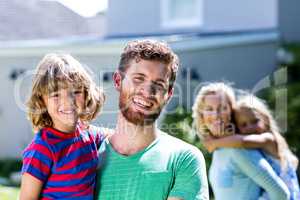 Happy family standing against house