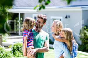 Parent carrying children in yard