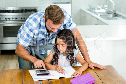 Father assisting daughter in using calculator