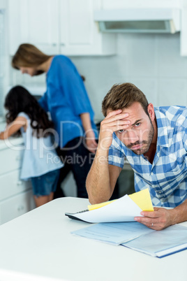 Worried father holding bills at home