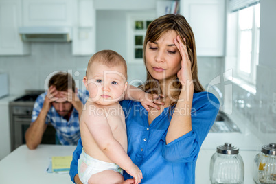 Worried mother carrying baby boy at home