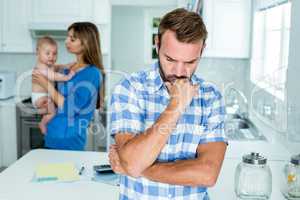 Upset man with family in kitchen