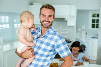 Portrait of happy father carrying son in kitchen Portrait of happy father carrying son in kitchen