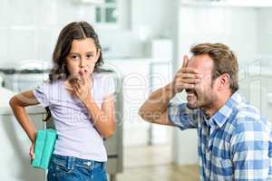Girl standing with gift while father covering his eyes