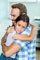Happy father hugging daughter at home