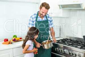 Father and daughter preparing food in kitchen