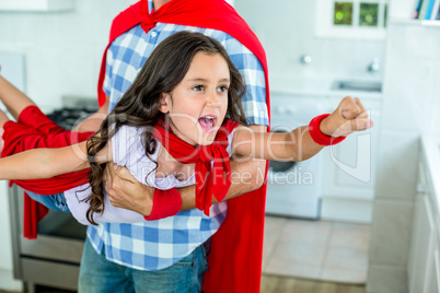 Father lifting girl in superhero costume