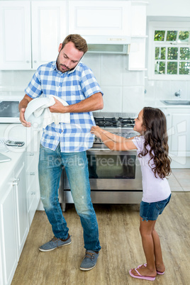 Father with mobile phone while daughter pulling him