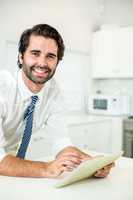 Confident businessman using digital tablet at table