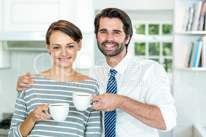 Happy couple drinking coffee at home