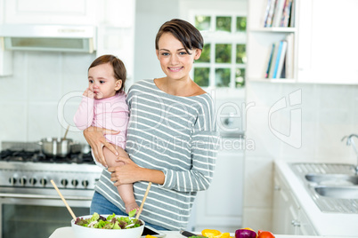 Happy mother with baby boy by kitchen counter