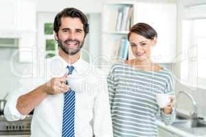 Portrait of happy businessman and woman with coffee