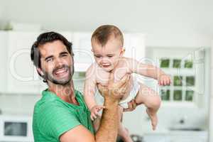 Happy father with son in kitchen at home