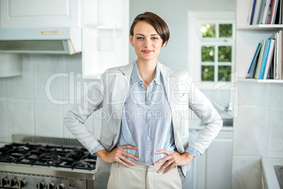 Confident businesswoman standing in kitchen