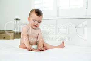 Baby boy playing with digital tablet on bed