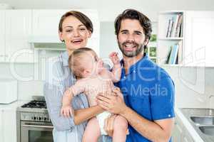 Happy parents with son in kitchen at home