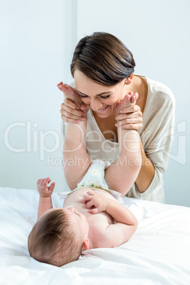 Mother playing with baby boy in bedroom