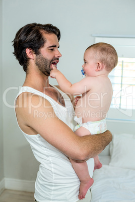 Father carrying playful boy