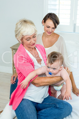 Grandmother and mother with baby boy at home