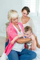 Grandmother and mother with baby boy at home