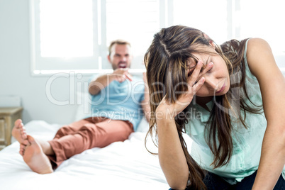 Irritated woman sitting while man shouting in background
