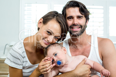 Happy parents with baby boy in bedroom