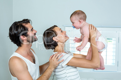 Parents playing with son in bedroom