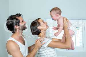 Parents playing with son in bedroom