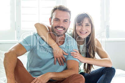 Couple smiling while relaxing on bed