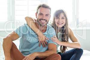 Couple smiling while relaxing on bed