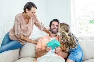 Daughter kissing father while mother sitting beside them