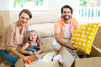 Happy family unpacking boxes in new house