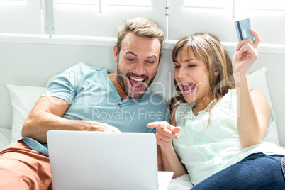 Couple screaming while looking in laptop