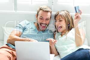 Couple screaming while looking in laptop