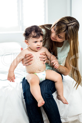 Mother sitting with son on bed