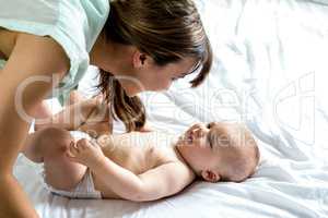 Woman playing with son on bed