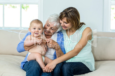 Grandmother and mother playing with cute baby boy