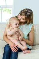Mother sitting with cute son on sofa