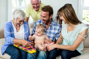 Multi-generation family showing xylophone to baby boy