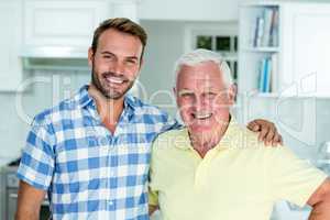 Happy man standing with father at home