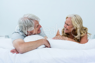 Happy senior couple relaxing on bed