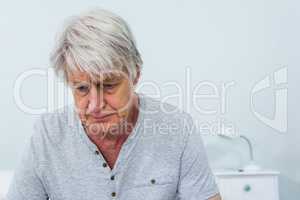 Sad senior man sitting at home