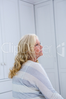 Thoughtful woman sitting at home