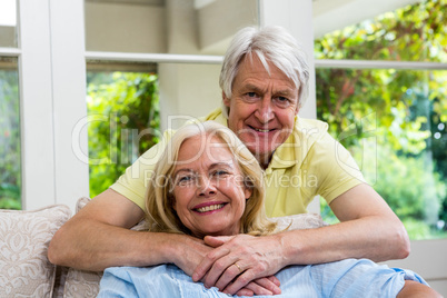 Happy senior couple sitting in living room at home