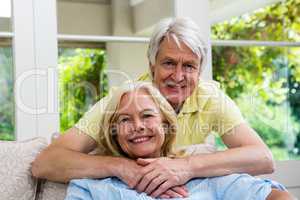 Happy senior couple sitting in living room at home