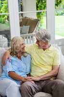 High angle view of happy senior couple sitting on sofa at home