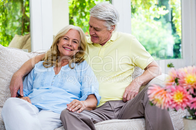 Romantic senior couple sitting on sofa at home