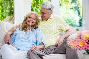 Romantic senior couple sitting on sofa at home