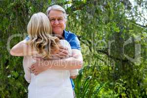 Senior man hugging woman at park