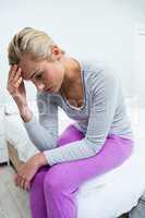 Young woman with headache sitting at home